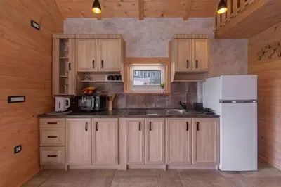 a kitchen with wooden cabinets and a white refrigerator at Resort pri Hrastu in Kamnik
