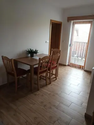 a dining room with a wooden table and chairs at Posestvo Rožengrunt pri Miheliču in Lokavec