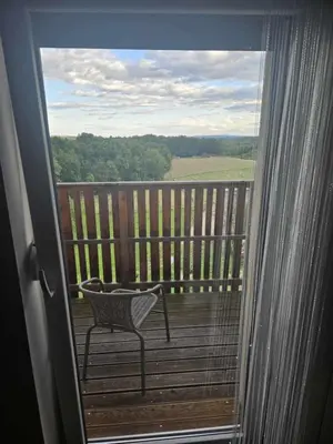 a balcony with a chair on a wooden deck at Posestvo Rožengrunt pri Miheliču in Lokavec