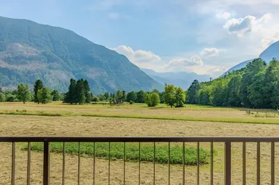 a fence in a field with mountains in the background at Apartment Hajdi with Sauna & Garage in Bovec