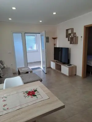 a living room with a table and a tv at Apartma Anci in Prosenjakovci