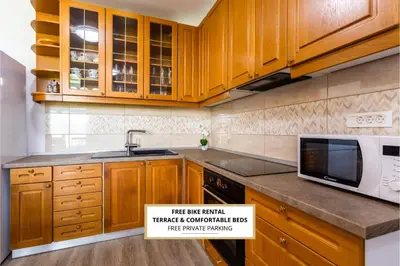 a kitchen with wooden cabinets and a microwave at Apartma Majdas in Loka pri Mengšu
