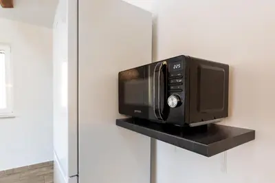 a microwave oven sitting on a shelf in a kitchen at Apartma Majdas in Loka pri Mengšu