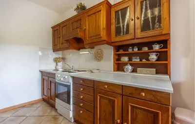 a kitchen with wooden cabinets and a sink and a stove at 1 Bedroom Beautiful Apartment In Divaca in Divača