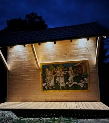 a painting on the side of a wooden building with lights at Apartments Kr'Bee in Mala Nedelja