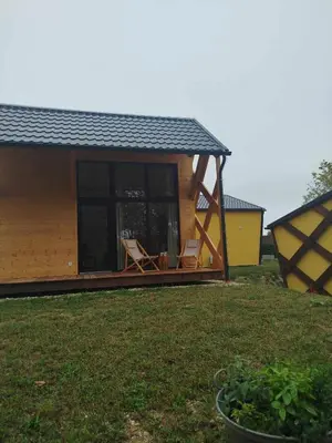 a house with two chairs in a yard at Apartments Kr'Bee in Mala Nedelja