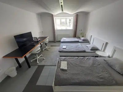 a room with three beds and a desk with a computer at ROSE house - greenline accomodations in Ljubljana