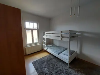 a bedroom with bunk beds in a room with a window at ROSE house - greenline accomodations in Ljubljana