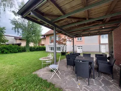 a patio with a table and chairs under a pergola at ROSE house - greenline accomodations in Ljubljana