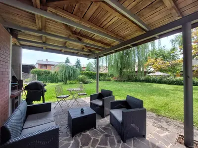 a patio with couches and a table and chairs at ROSE house - greenline accomodations in Ljubljana
