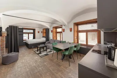a kitchen and living room with a table and a couch at Aroma apartments in Ljubljana