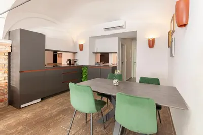 a kitchen and dining room with a table and green chairs at Aroma apartments in Ljubljana