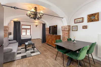 a living room with a table and a bedroom at Aroma apartments in Ljubljana