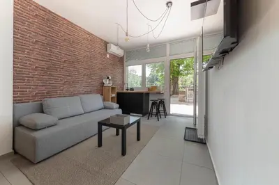 a living room with a couch and a brick wall at Aroma apartments in Ljubljana