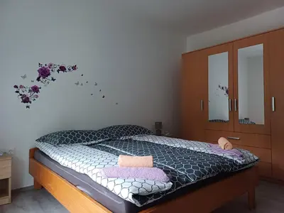 a bedroom with a bed and a dresser and mirror at Apartma Ginga in Osilnica