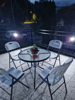 a table and chairs on a patio at night at Apartma Ginga in Osilnica