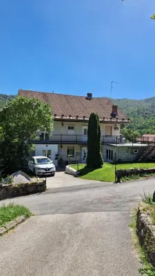 a house with a car parked in a driveway at Apartma Ginga in Osilnica