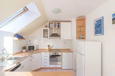 a kitchen with white cabinets and a white refrigerator at Fine Stay Apartments in Žirovnica