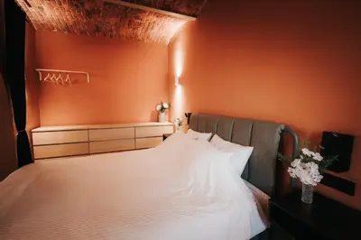 a bedroom with a bed with an orange wall at Luxury Residence Metlika in Metlika