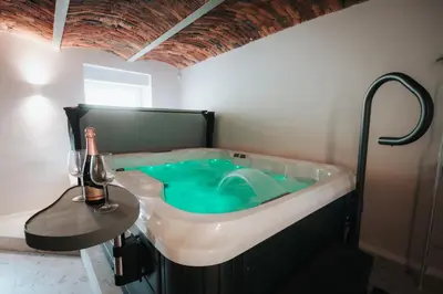 a bathroom with a tub with blue water in it at Luxury Residence Metlika in Metlika