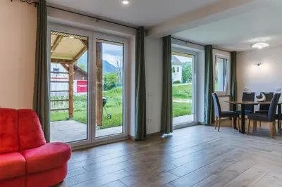 a living room with glass doors and a red couch at Pogacar Apartments in Bled