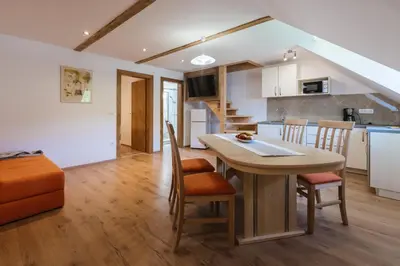 a kitchen and living room with a table and chairs at Pogacar Apartments in Bled