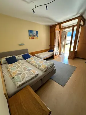 a bedroom with a bed and a door to a balcony at Apartma Mimi in Bovec