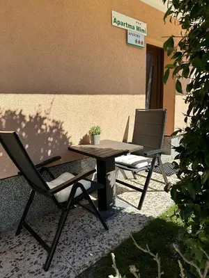 a picnic table and two chairs sitting next to a building at Apartma Mimi in Bovec