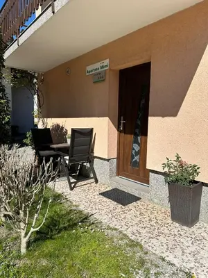 a patio with a table and chairs next to a door at Apartma Mimi in Bovec