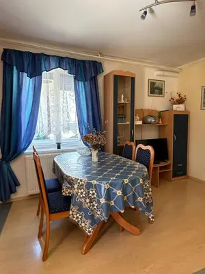 a dining room with a table with blue curtains and chairs at Apartma Mimi in Bovec