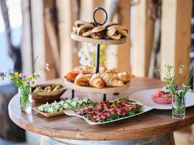 a table with three tiered plates of pastries and bread at Villa Palenk Logar Valley in Solčava
