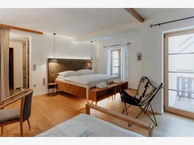 a bedroom with a bed and a chair in it at Villa Palenk Logar Valley in Solčava