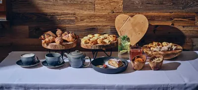 a table with several baskets of different types of bread at Villa Palenk Logar Valley in Solčava