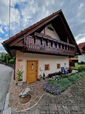 a house with a wooden door and a balcony at House 29 in Begunje na Gorenjskem