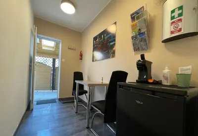 a waiting room with a table and a coffee machine at Roses Apartment Prijeten apartma za dve osebi in Mengeš