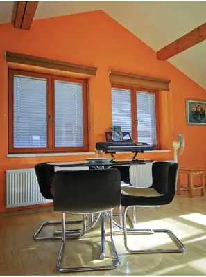 an orange room with chairs and a table and windows at Morning sunshine in Bled