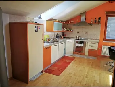 a kitchen with orange walls and a white refrigerator at Morning sunshine in Bled