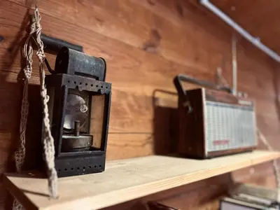 an old radio sitting on a wooden shelf at Somova gora chalet in the woods in Kočevje