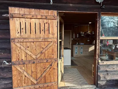 an open door of a barn with a wooden gate at Somova gora chalet in the woods in Kočevje