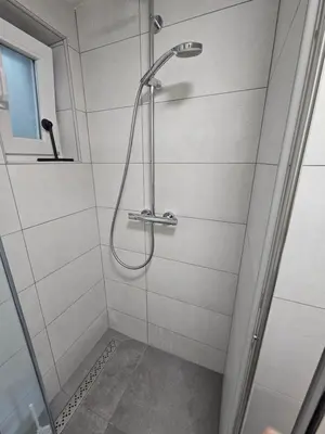 a shower with a shower head in a bathroom at Red Riding Hood in Ljubljana