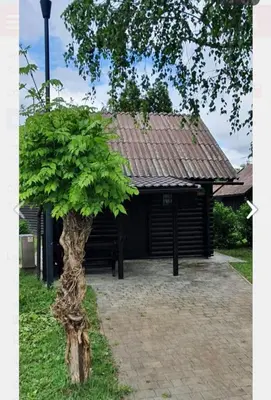a building with a tree in front of it at Hiška 111 s kopalnimi kartami in Brežice