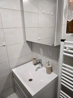 a bathroom with a white sink and a mirror at Hiška 111 s kopalnimi kartami in Brežice