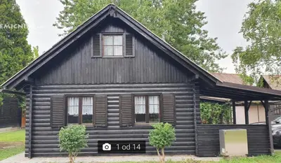 a log cabin house with two trees in front of it at Hiška 111 s kopalnimi kartami in Brežice