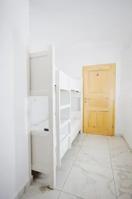 a room with white walls and a wooden door at Hotel Šiška in Ljubljana