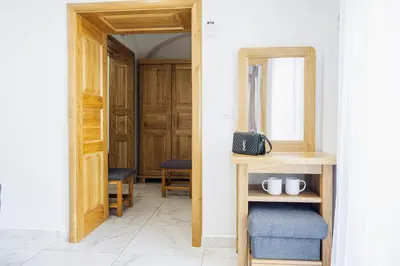 a hallway with a table and a mirror and a chair at Hotel Šiška in Ljubljana