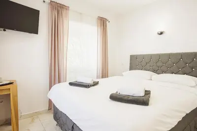 a bedroom with a large white bed with two pillows at Hotel Šiška in Ljubljana