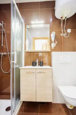 a bathroom with a shower and a sink and a toilet at Hotel Šiška in Ljubljana