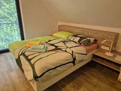 a bedroom with a large bed with a wooden headboard at Hiša Oblak in Gozd Martuljek