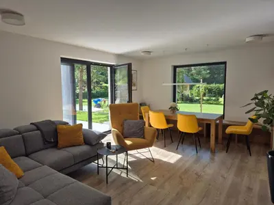 a living room with a couch and a table and chairs at Hiša Oblak in Gozd Martuljek