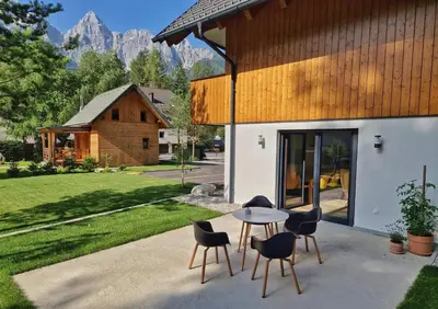 a patio with a table and chairs in front of a building at Hiša Oblak in Gozd Martuljek